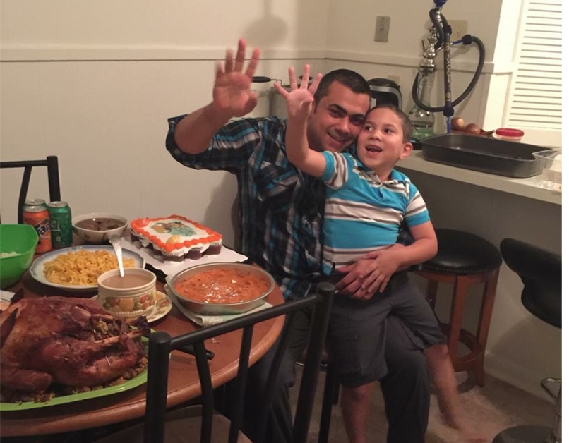 Father and son smiling and waving