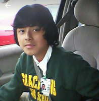 Hispanic Boy wearing a green sweatshirt