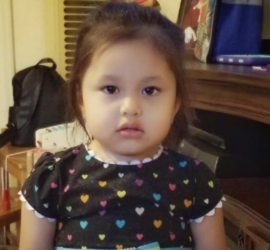 Hispanic girl toddler wearing a dress with colored hearts on it