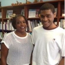 African American Mother and her adult son standing in front of library book shelves