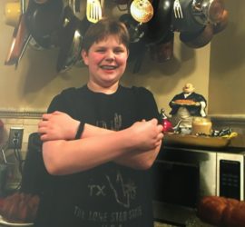 Teen smiling folding his arms wearing a black shirt