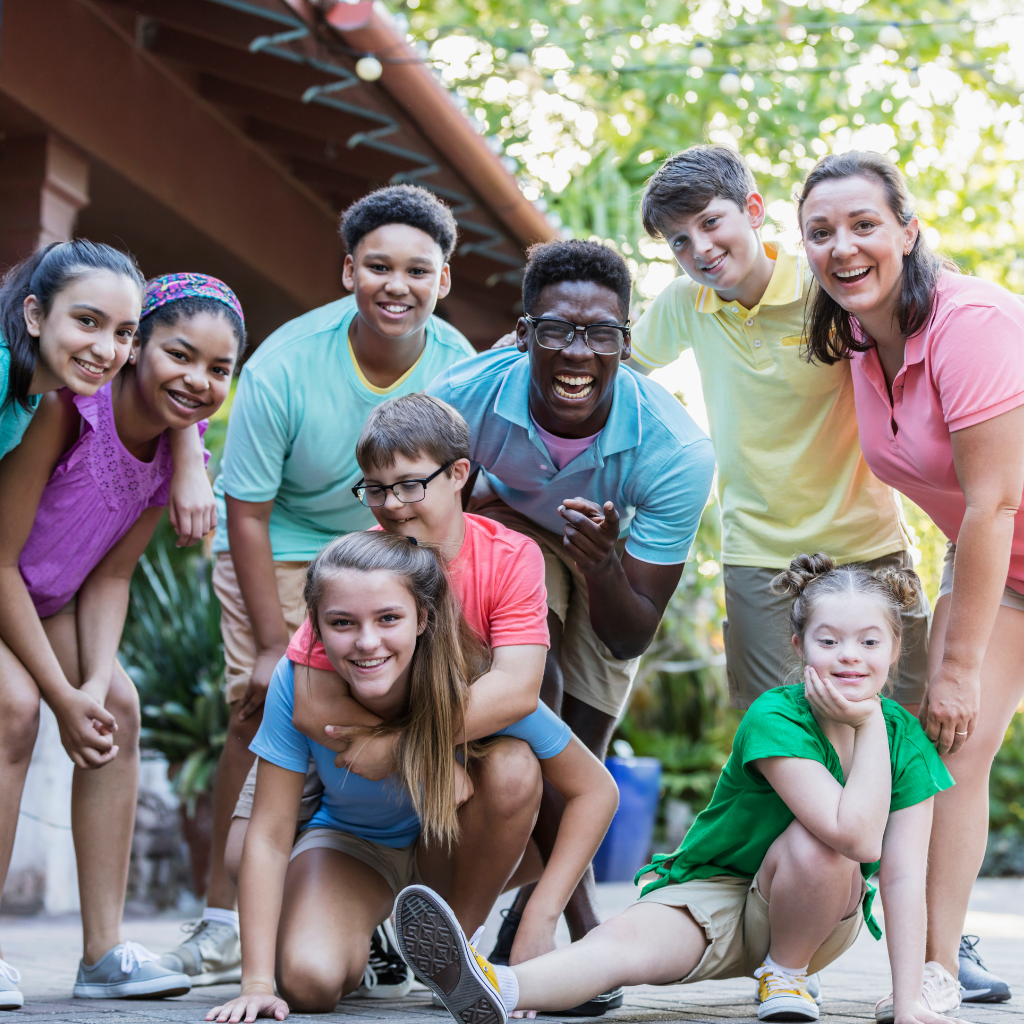 Group of individuals of various races, ages, and abilities smiling