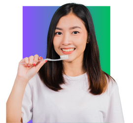 Asian teen girl with brown hair holding a toothbrush and smiling